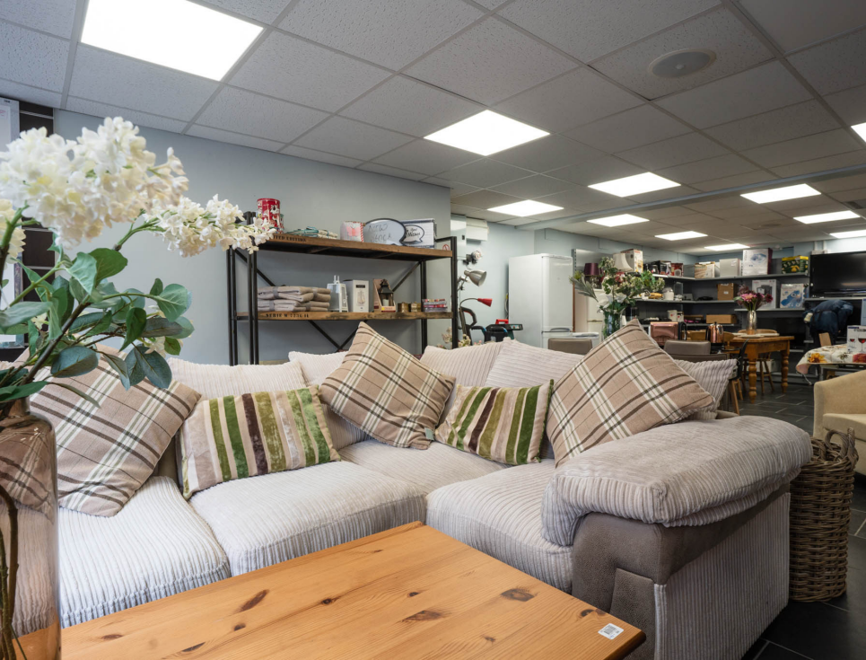 This button takes you to a page about donating furniture to St Richard's Hospice. The image shows a large, cream coloured corner sofa and wooden coffee table.